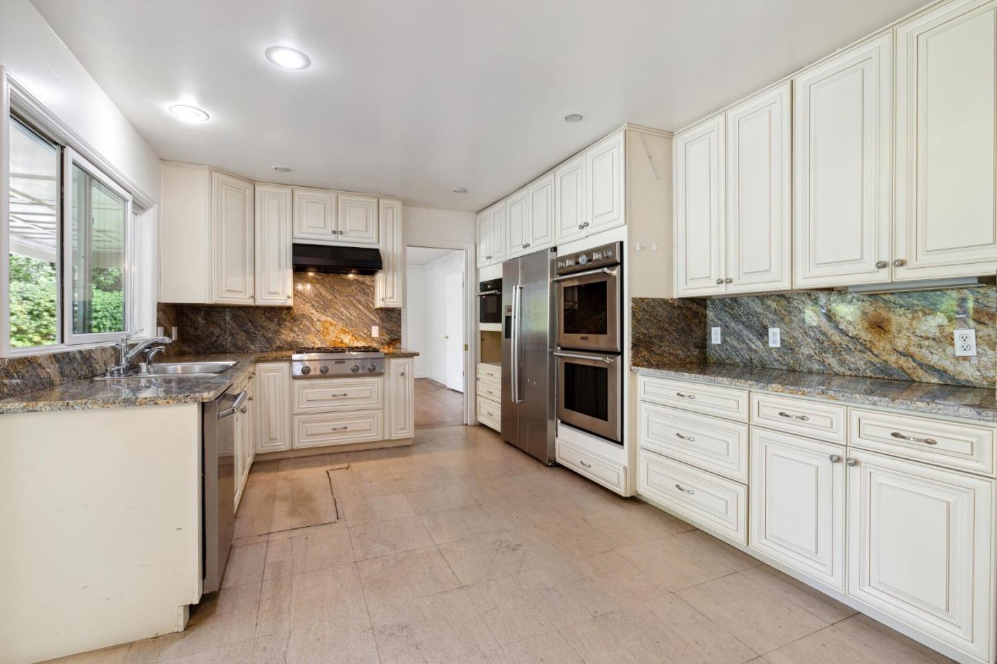 243 Selby Lane Atherton, CA 94027 - Photo 20 of 90 a kitchen with granite countertop white cabinets and stainless steel appliances