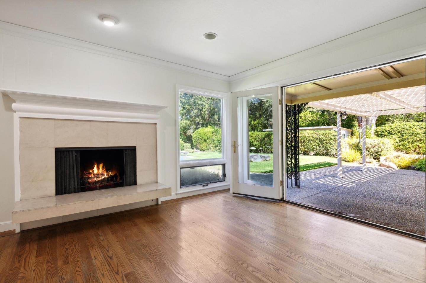 243 Selby Lane Atherton, CA 94027 - Photo 25 of 90 a view of an empty room with wooden floor fireplace and a window