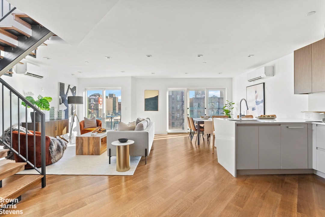 a living room with furniture a wooden floor and next to a window