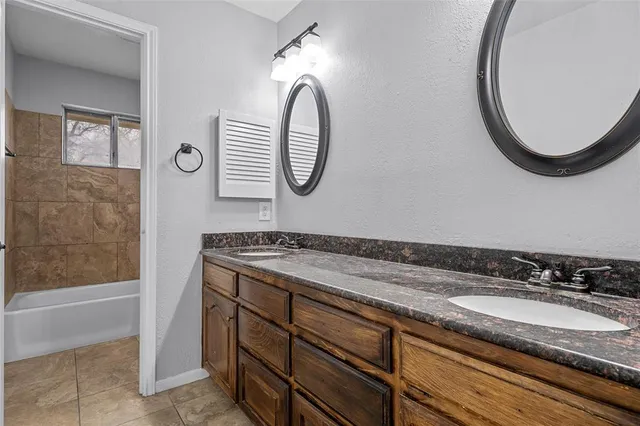 a bathroom with a granite countertop sink and a mirror