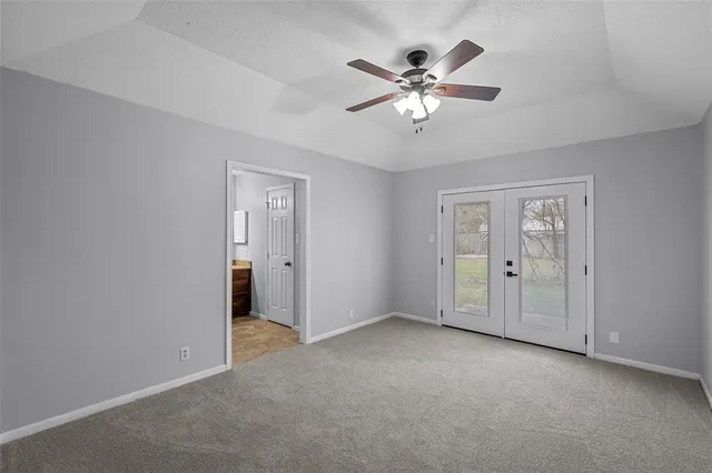 a view of an empty room with chandelier fan