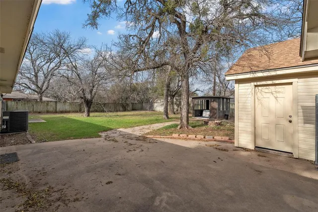 a view of a house with a big yard and large tree