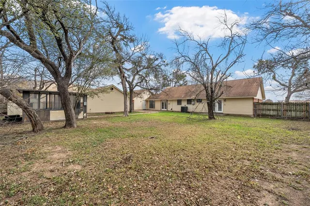 a view of a house with backyard and tree