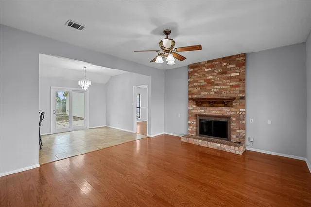 a view of an empty room with a fireplace and a window