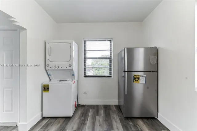 a view of kitchen with a refrigerator a stove top oven and a window