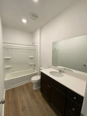 a bathroom with a granite countertop sink a toilet and bathtub