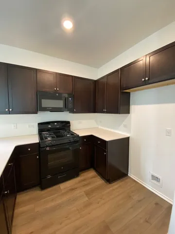 a kitchen with wooden cabinets and black stainless steel appliances