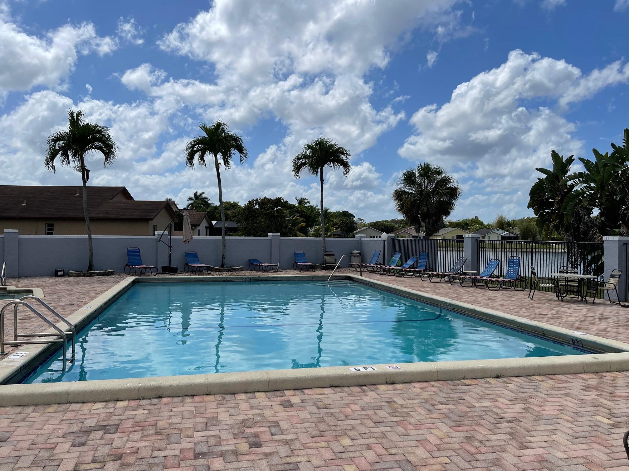 9151 Pine Springs Drive Boca Raton, FL 33428 - Photo 19 of 21 a view of a swimming pool with a lounge chairs