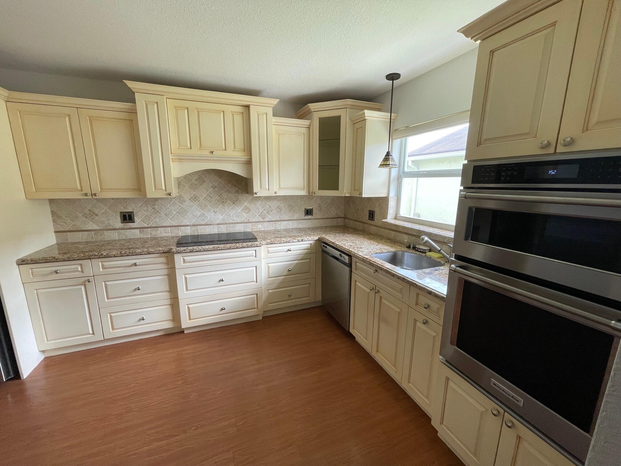 9151 Pine Springs Drive Boca Raton, FL 33428 - Photo 6 of 21 a kitchen with granite countertop cabinets stainless steel appliances and a sink