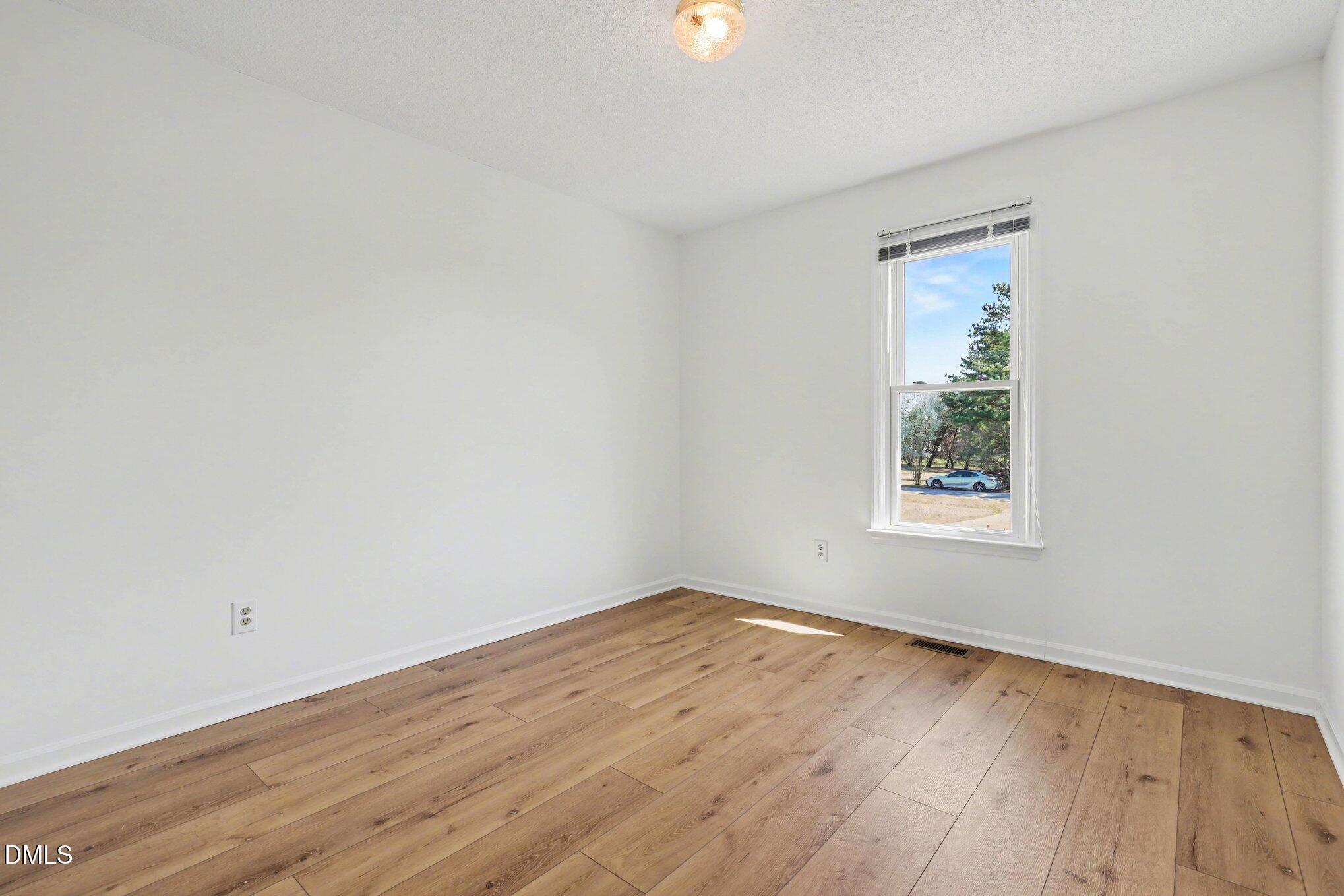 2004 Little Pond Place Willow Spring, NC 27592 - Photo 15 of 32 an empty room with wooden floor and windows