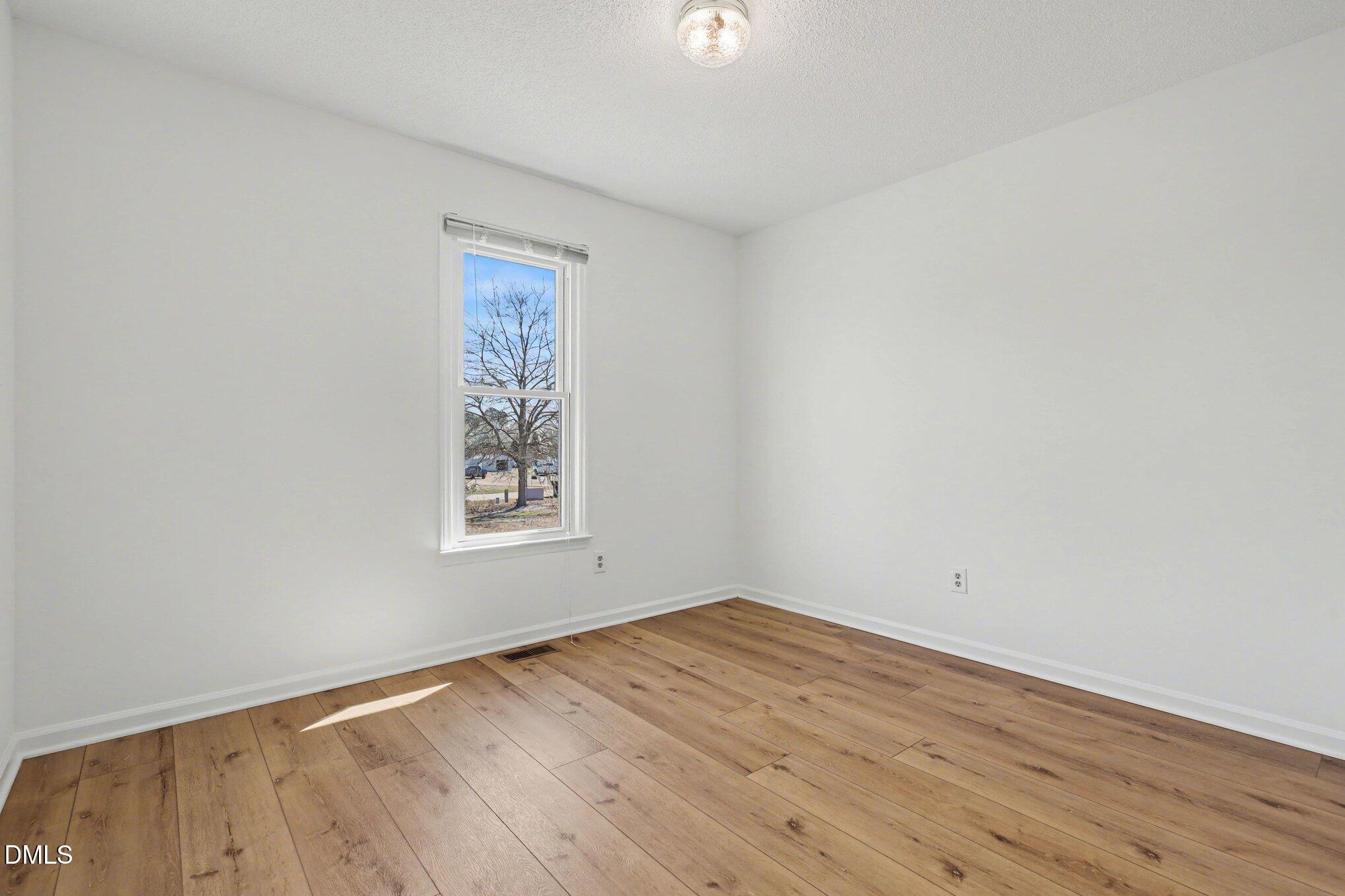 2004 Little Pond Place Willow Spring, NC 27592 - Photo 16 of 32 wooden floor in an empty room with a window