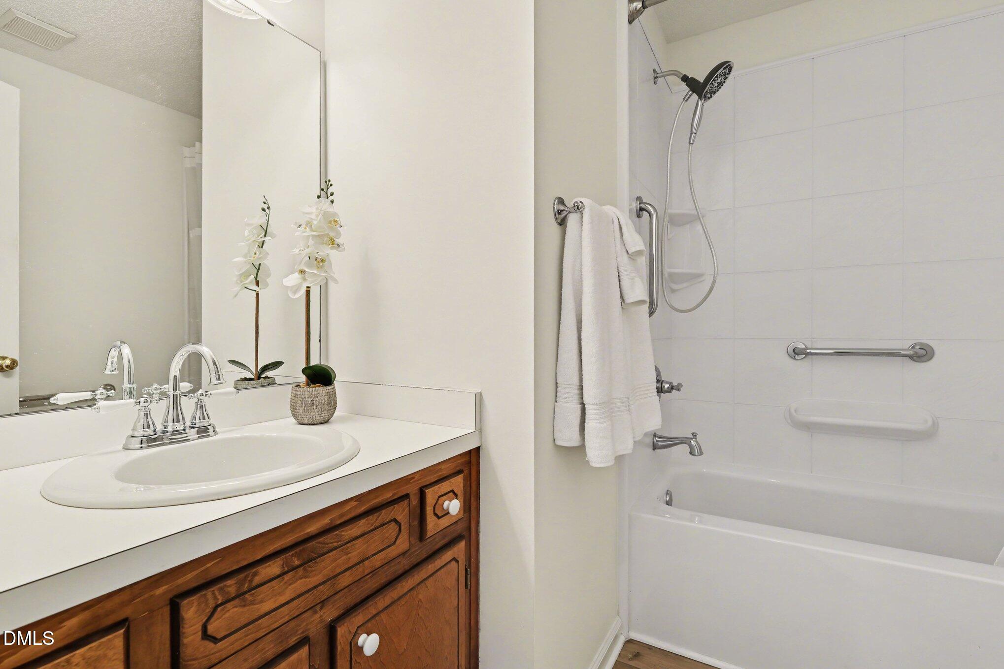 2004 Little Pond Place Willow Spring, NC 27592 - Photo 17 of 32 a bathroom with a granite countertop sink a mirror and a bathtub