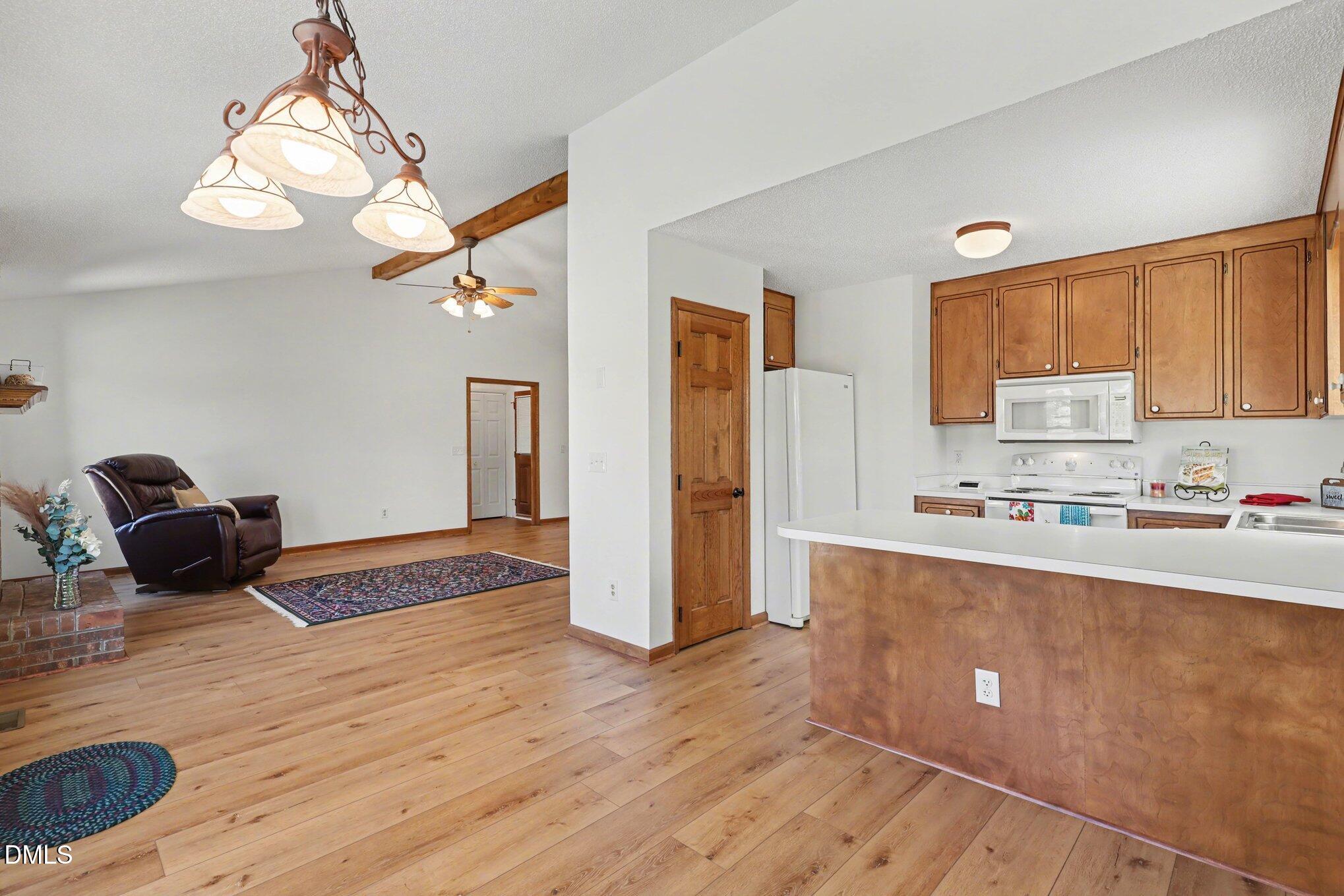 2004 Little Pond Place Willow Spring, NC 27592 - Photo 7 of 32 a kitchen with stainless steel appliances granite countertop a refrigerator a sink dishwasher a stove and white countertops with wooden floor