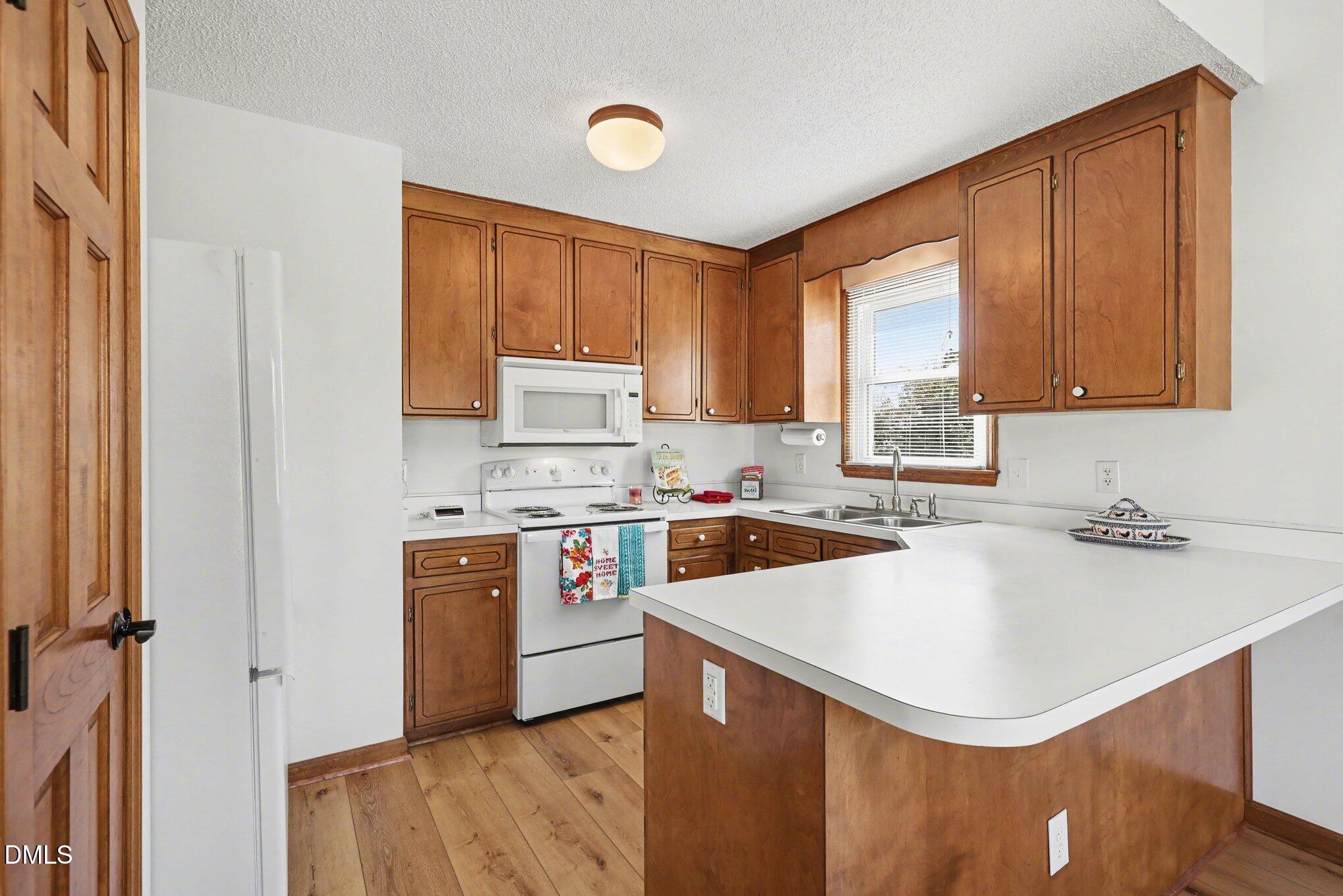 2004 Little Pond Place Willow Spring, NC 27592 - Photo 8 of 32 a kitchen with a sink a stove a refrigerator cabinets and a window