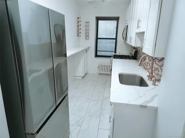 a kitchen with a refrigerator sink and cabinets