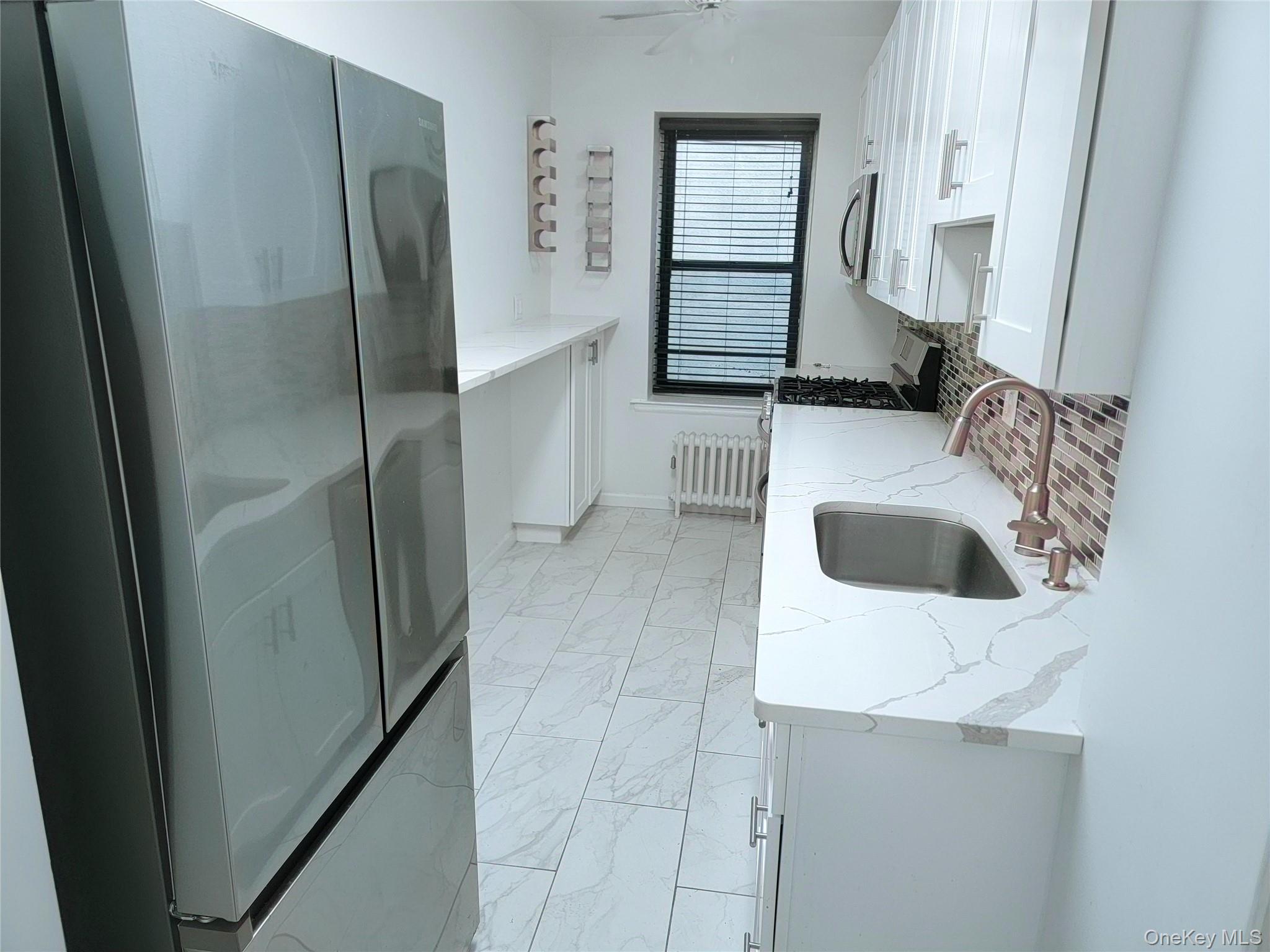 a kitchen with a refrigerator sink and cabinets