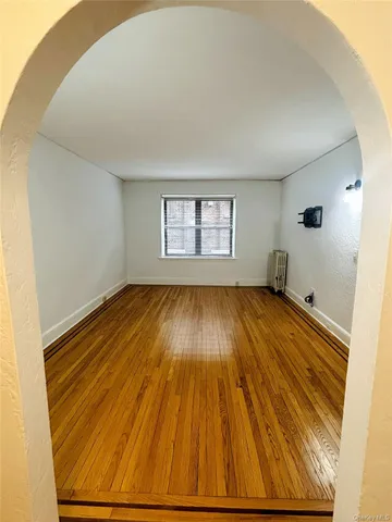 a view of a room with wooden floor and window
