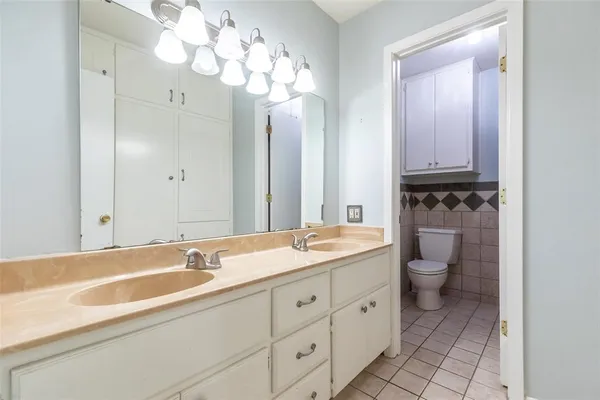 a bathroom with a sink a toilet and a large mirror