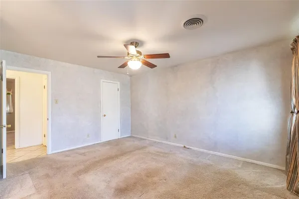 an empty room with a ceiling fan and a window