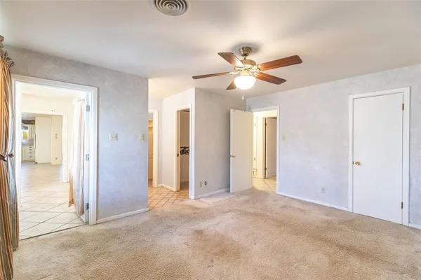an empty room with closet and a ceiling fan