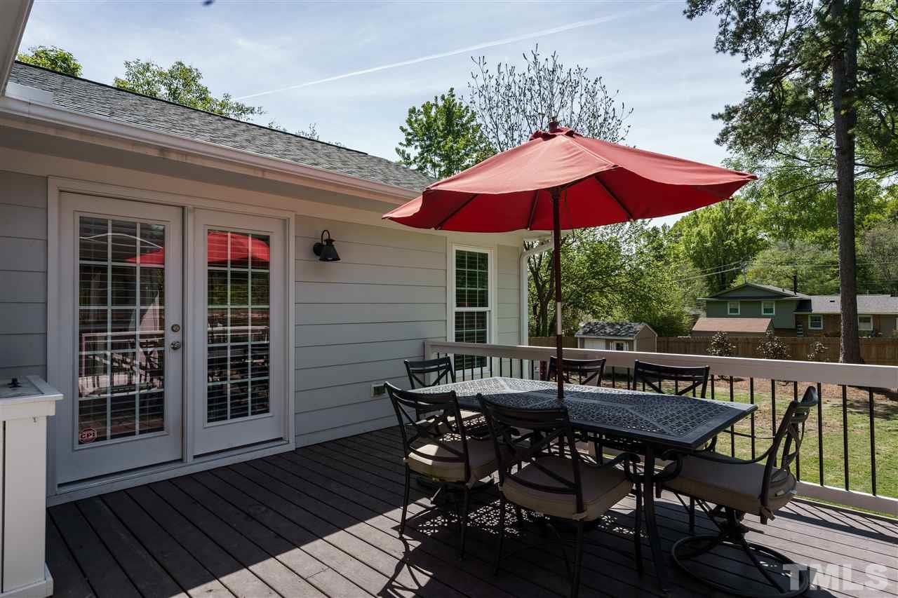 300 Compton Road Raleigh, NC 27609 - Photo 22 of 25 a view of a house with table and chairs under an umbrella
