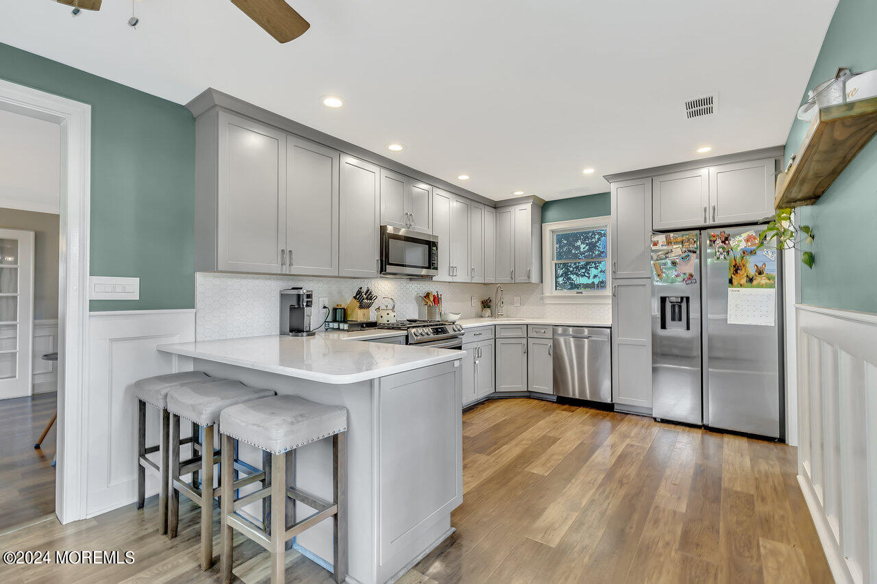 238 County Road 539 Cream Ridge, NJ 08514 - Photo 10 of 32 a kitchen with stainless steel appliances a refrigerator a sink dishwasher a stove and white cabinets with wooden floor