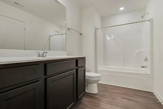 a bathroom with a sink a toilet a mirror and shower