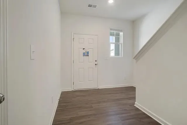 a view of an empty room with wooden floor