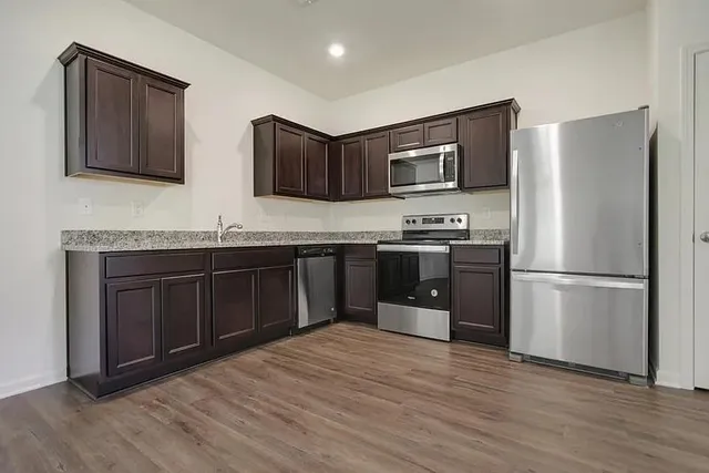 a kitchen with stainless steel appliances granite countertop a sink stove and refrigerator