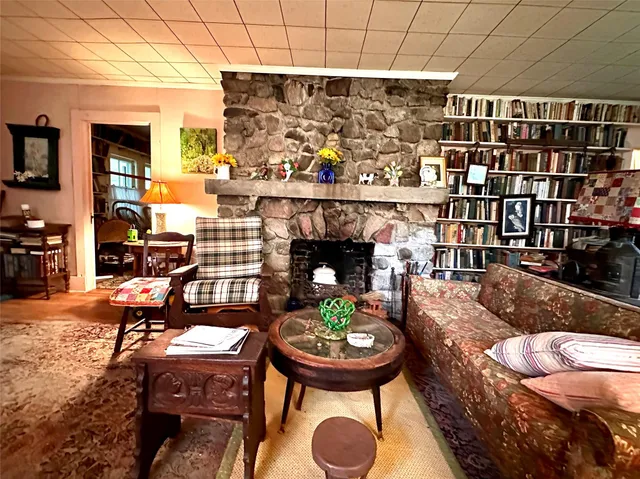 a living room with fireplace furniture and a rug