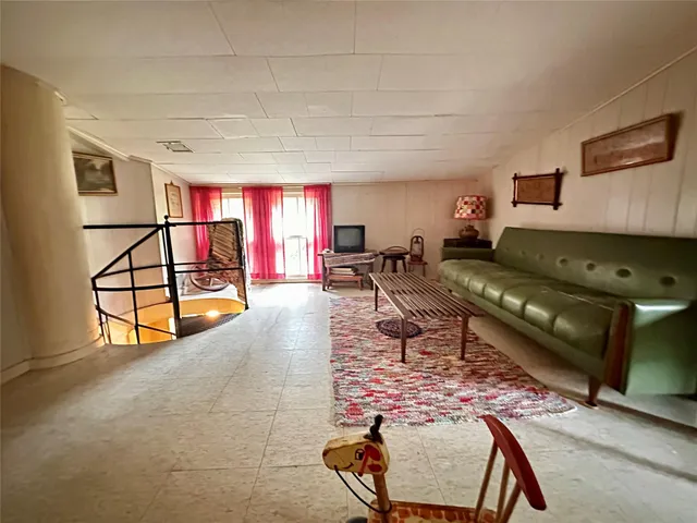 a living room with furniture gym equipment and a rug