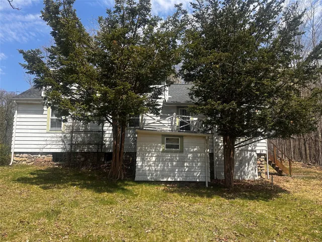 a view of a house with a large tree and a yard