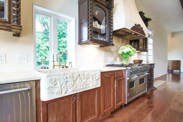 a kitchen with stainless steel appliances a stove a sink and a wooden floors