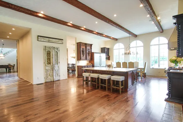 a dining hall with stainless steel appliances granite countertop a barbecue seating space a sink and a large window