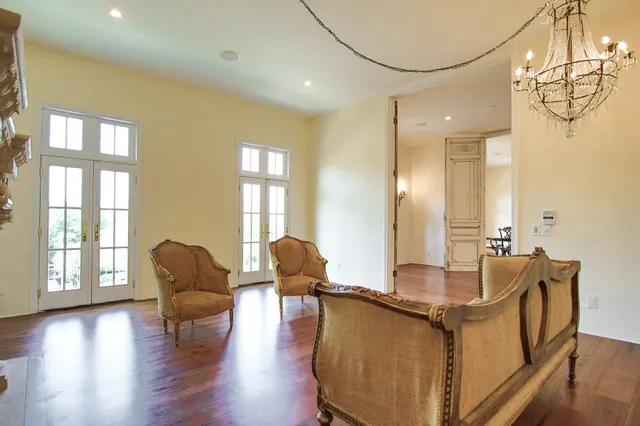 a living room with couches a coffee table and chandelier