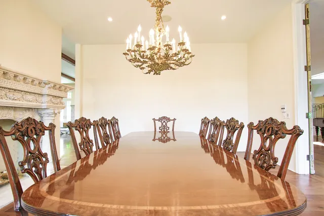 a view of a dining room with furniture a chandelier and kitchen view