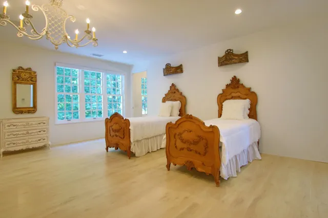 a spacious bedroom with a bed and a chandelier