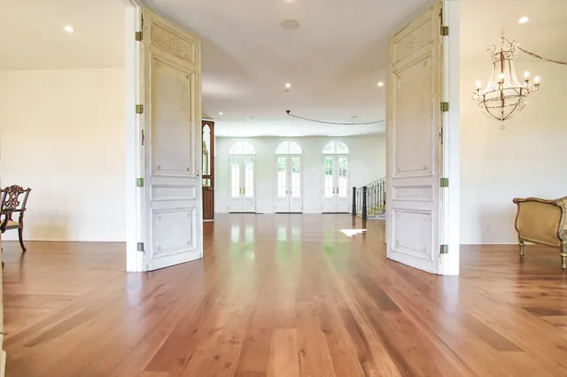 a view of a hallway with wooden floor and windows