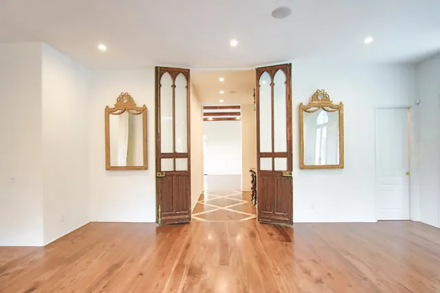 a view of empty room with wooden floor and windows