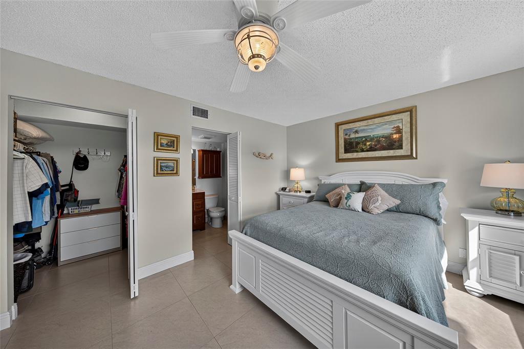 1550 Northwest 80th Avenue, Unit 303 Margate, FL 33063 - Photo 26 of 41 a bedroom with a bed and a chandelier