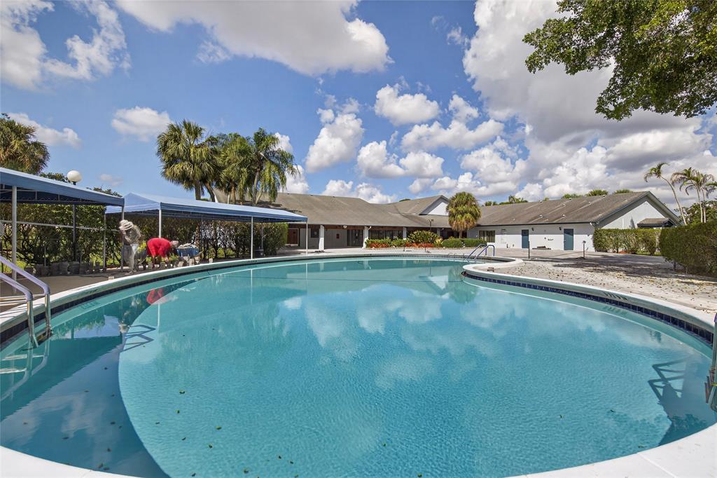 1550 Northwest 80th Avenue, Unit 303 Margate, FL 33063 - Photo 38 of 41 a view of a swimming pool with an outdoor seating