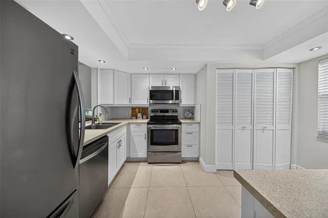 a kitchen with granite countertop a refrigerator stove and microwave