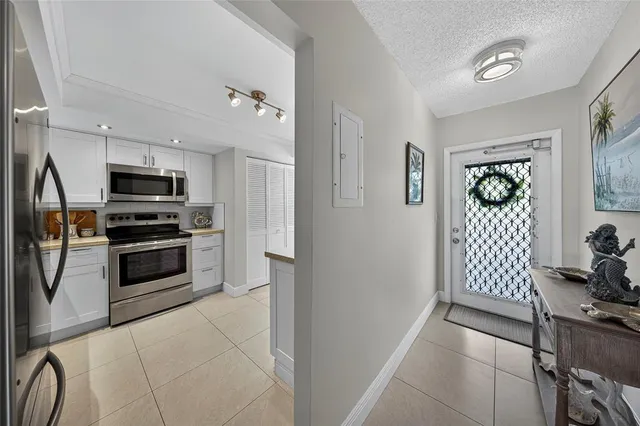 a kitchen with granite countertop a refrigerator and a stove top oven