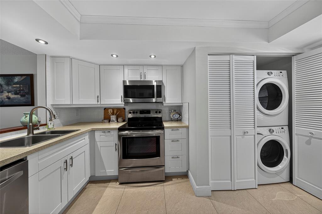 1550 Northwest 80th Avenue, Unit 303 Margate, FL 33063 - Photo 7 of 41 a kitchen with a stove top oven sink and cabinets
