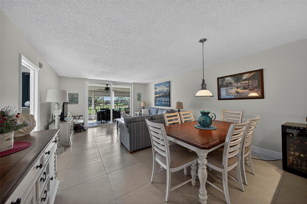 1550 Northwest 80th Avenue, Unit 303 Margate, FL 33063 - Photo 10 of 41 a view of a dining room and livingroom with furniture wooden floor a rug a painting and a chandelier