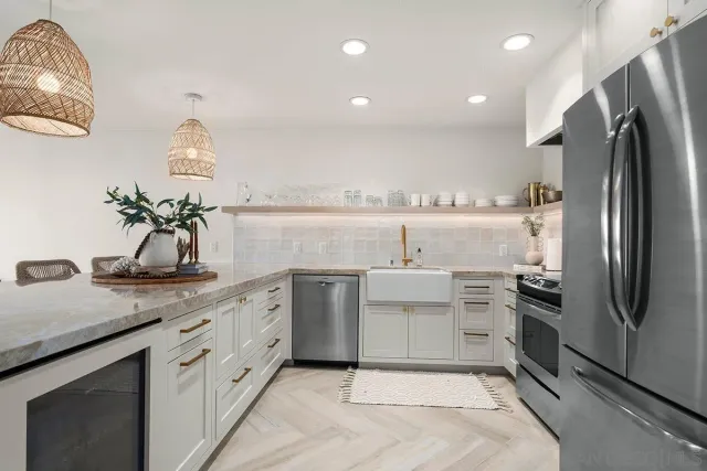 a kitchen with kitchen island granite countertop a sink stainless steel appliances and cabinets