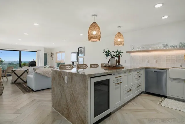 a kitchen with kitchen island granite countertop a stove and a sink