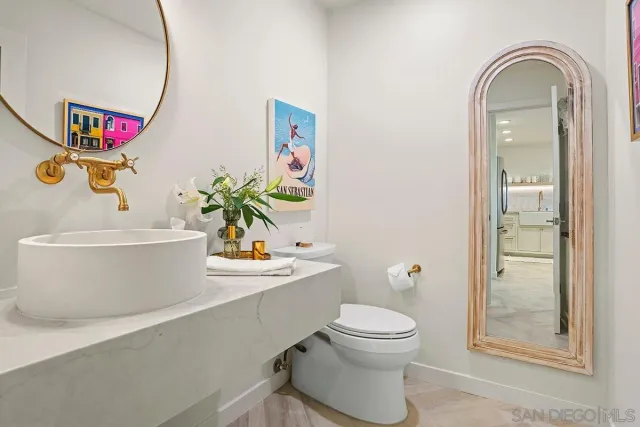a bathroom with a toilet a sink and a mirror