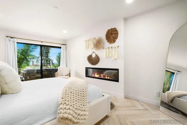 a bedroom with a bed a mirror and a large window