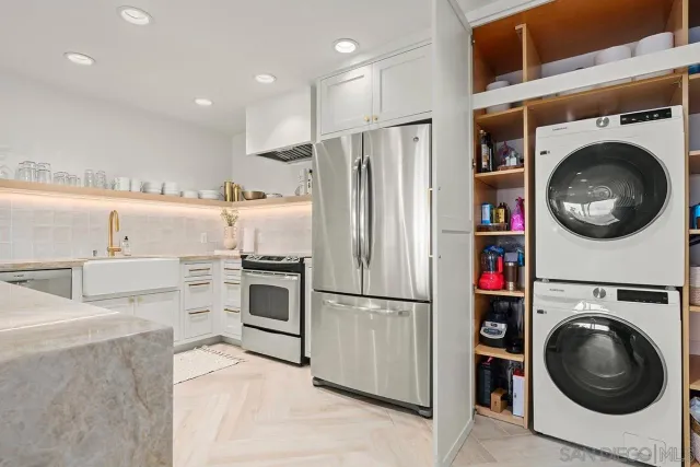 a kitchen with a refrigerator and washer dryer
